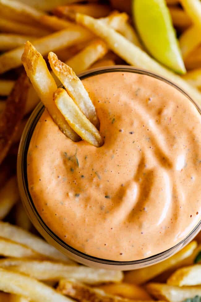 homemade chipotle mayo sauce in a jar with fresh fries dipped in.