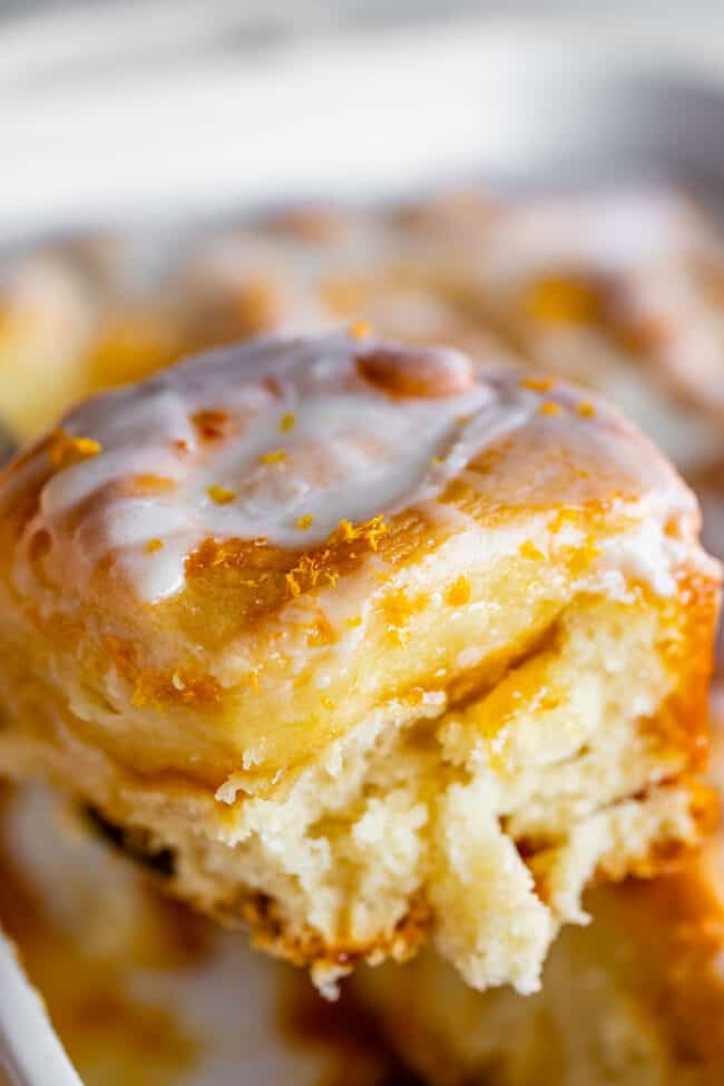 meyer lemon sweet roll with glaze being lifted on a spatula