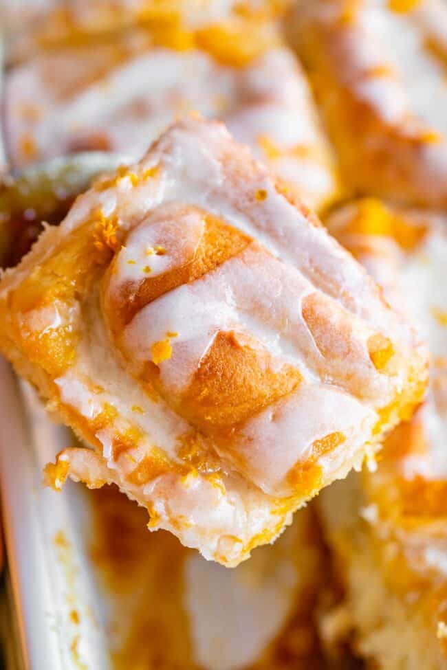 meyer lemon sweet roll being lifted from a white pan