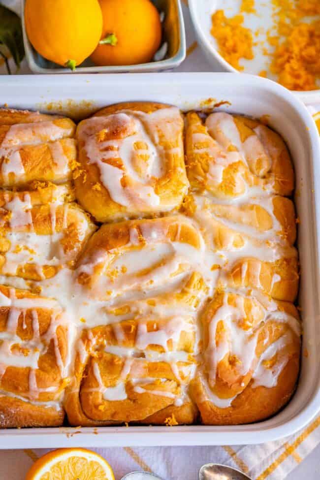 overhead photo of meyer lemon rolls in a 9x3 inch pan with lemons on the side