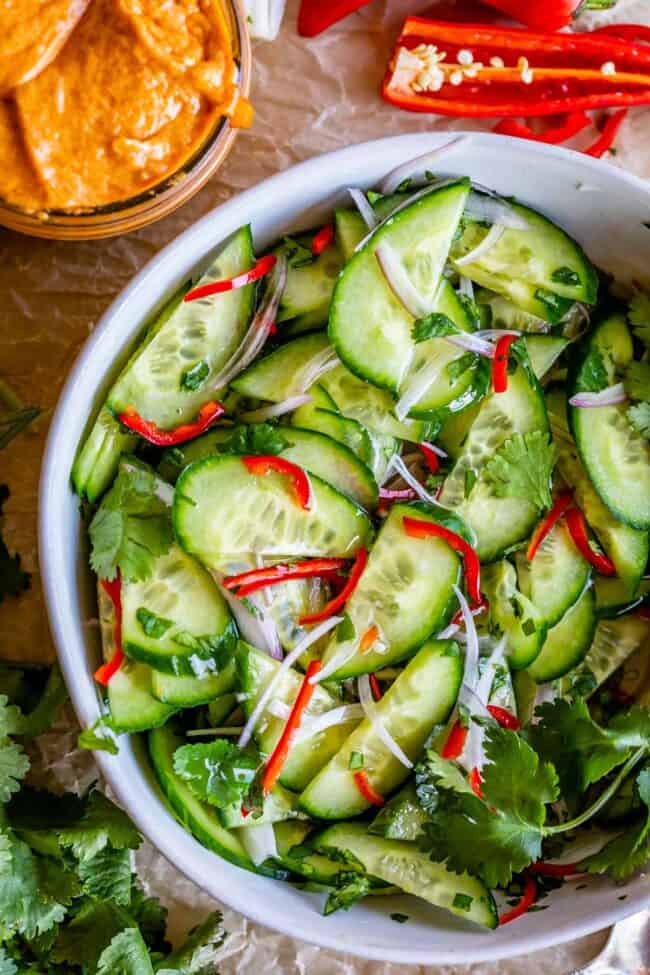 thai pickled cucumber, shallots, red pepper, and cilantro in a white bowl.