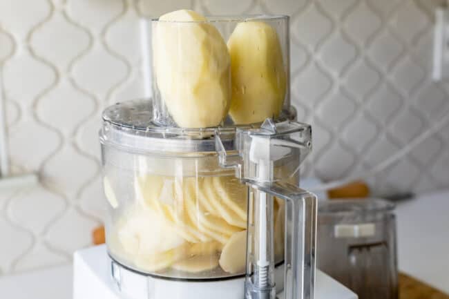 potatoes in a food processor, ready to be sliced.