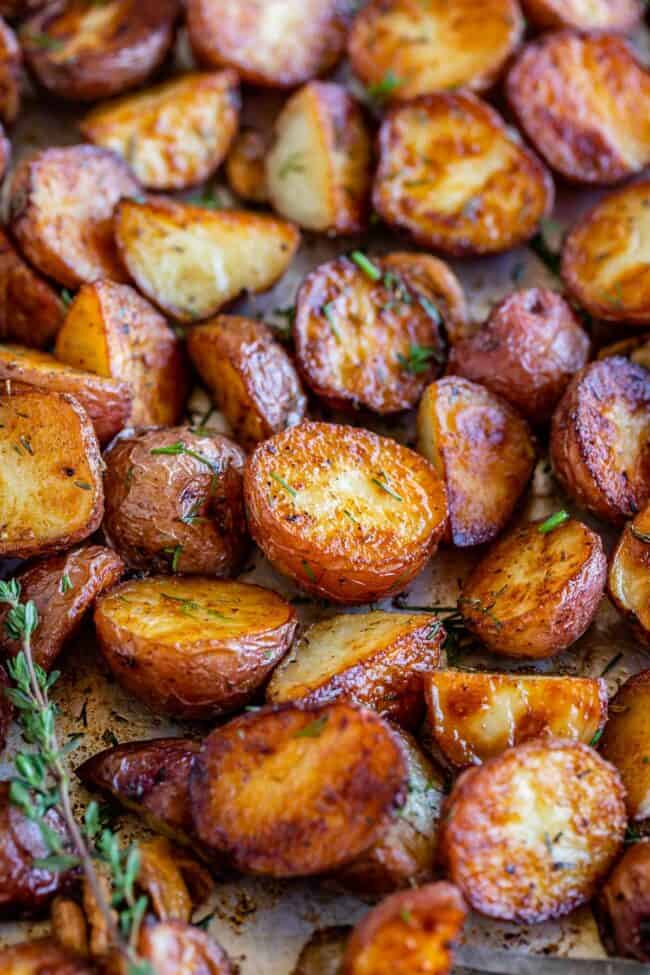 crispy roasted red potatoes on a sheet pan with fresh thyme.