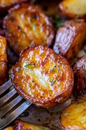 roasted red skin potatoes on a fork sprinkled with herbs