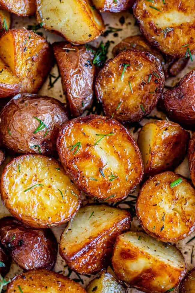 oven roasted red potatoes on a pan sprinkled with herbs.