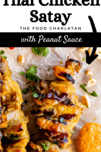 thai chicken satay skewer on parchment paper with peanut sauce