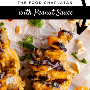 thai chicken satay skewer on parchment paper with peanut sauce