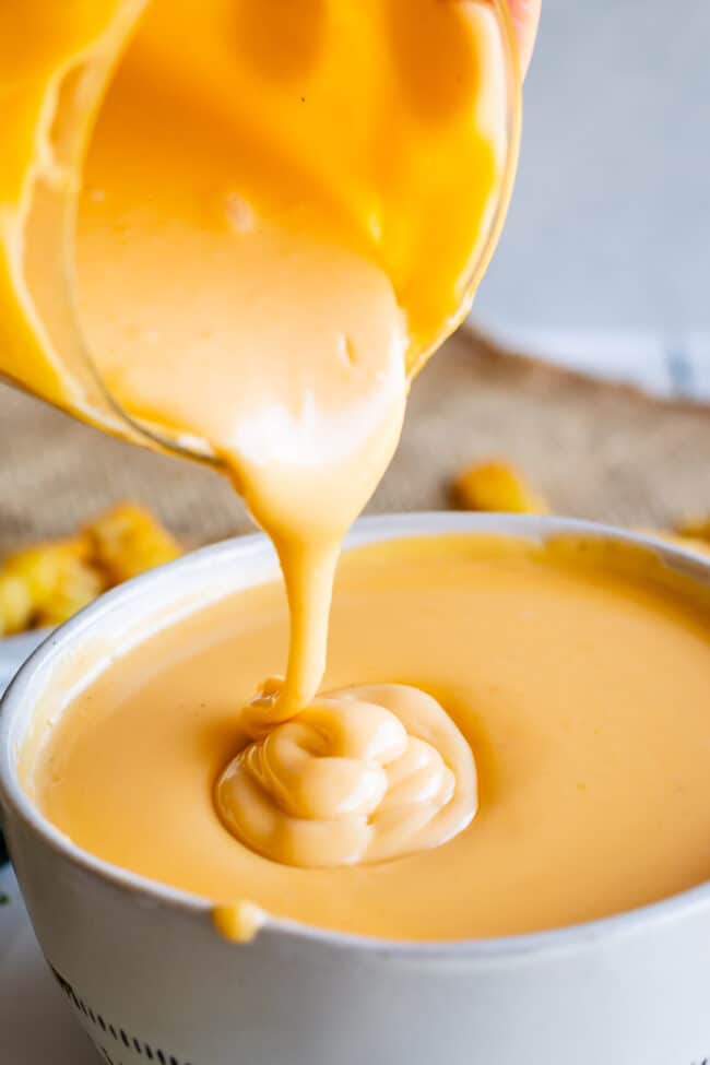 shake shack cheese sauce being poured into a white bowl