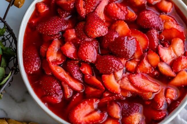 sliced strawberry topping in a white bowl.
