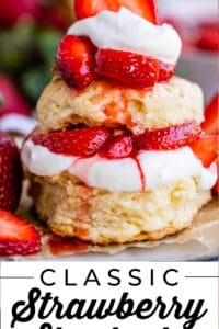 stacked biscuits of strawberry shortcake with whipped cream on a plate