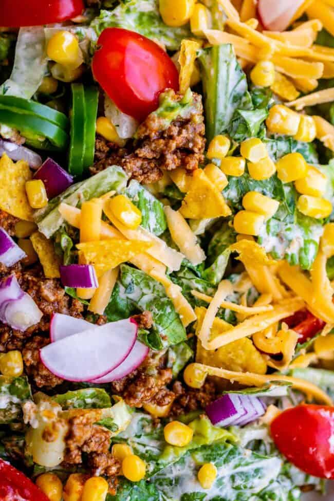 taco salad ingredients mixed together in a bowl.