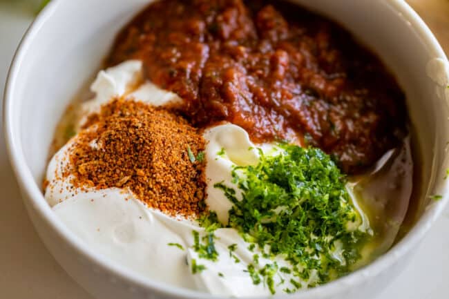 ingredients in a bowl for creamy salsa salad dressing.