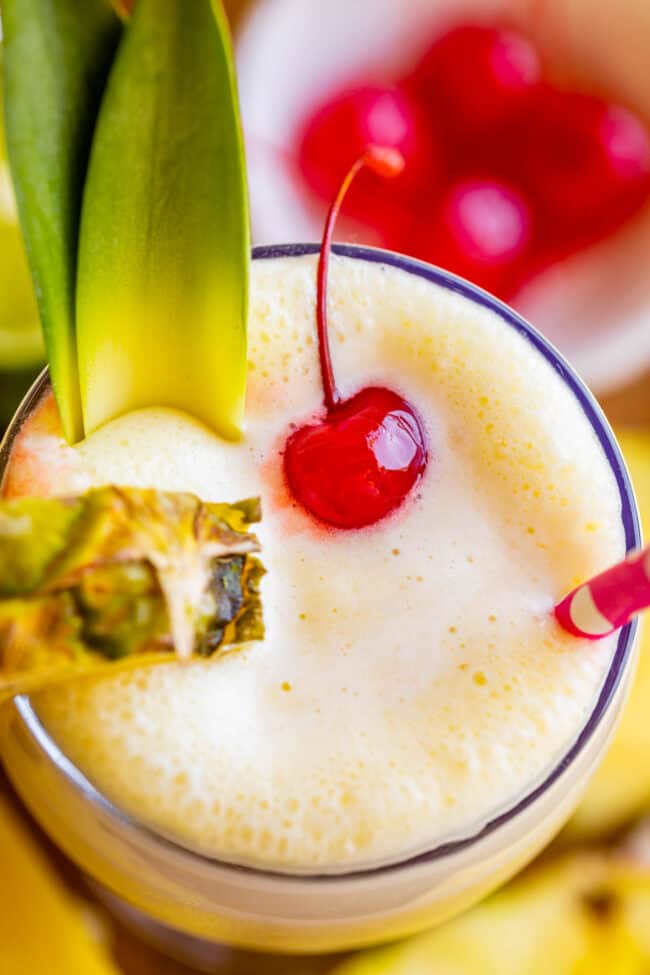 virgin pina colada with pineapple slices, maraschino cherry, and a straw.