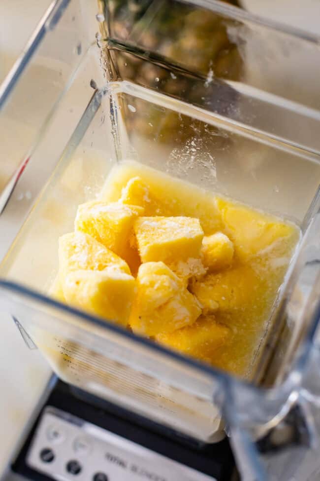 frozen pineapple in a blender with pineapple juice.