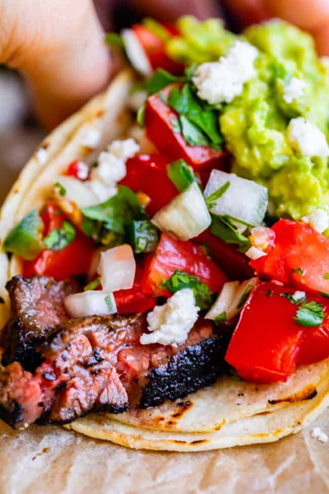 a carne asada taco with guacamole and pico de gallo.