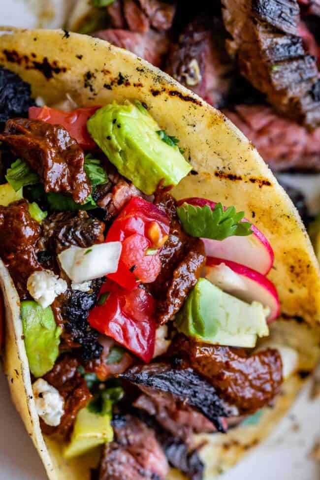 carne asada in a taco with avocados and pico de gallo.