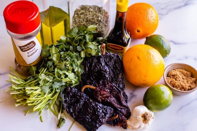 all the ingredients needed for a beef mojo marinade: cilantro, peppers, orange, lime, etc.