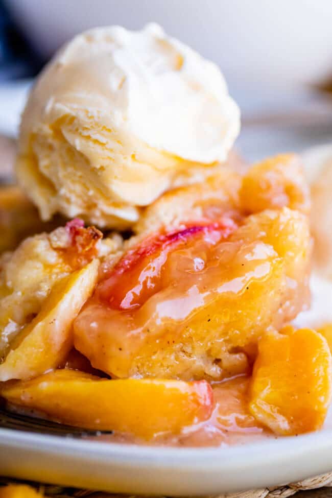 fresh peach cobbler on a plate topped with ice cream