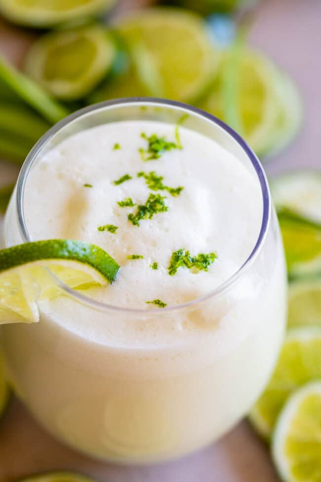 brazilian limeade in a glass with lime zest garnish.