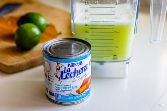 La Lechera brand sweetened condensed milk, with limeade in the background.