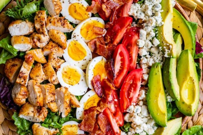 cobb salad ingredients in rows in a bowl.