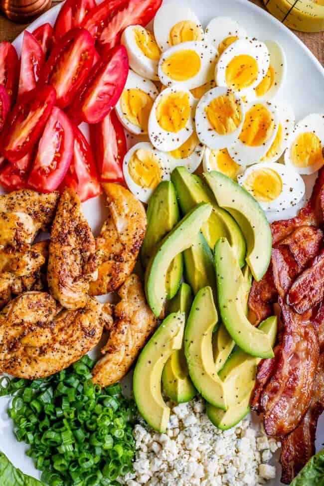 cobb salad ingredients sliced on a white platter.