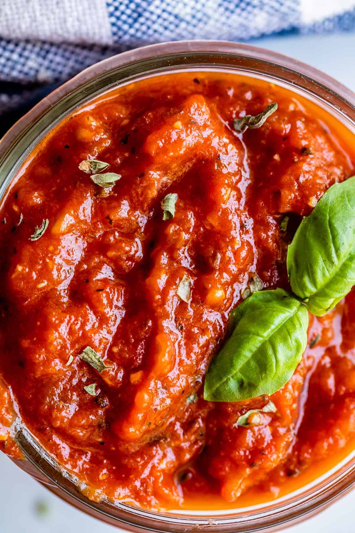 best pizza sauce in a mason jar with basil and oregano garnish