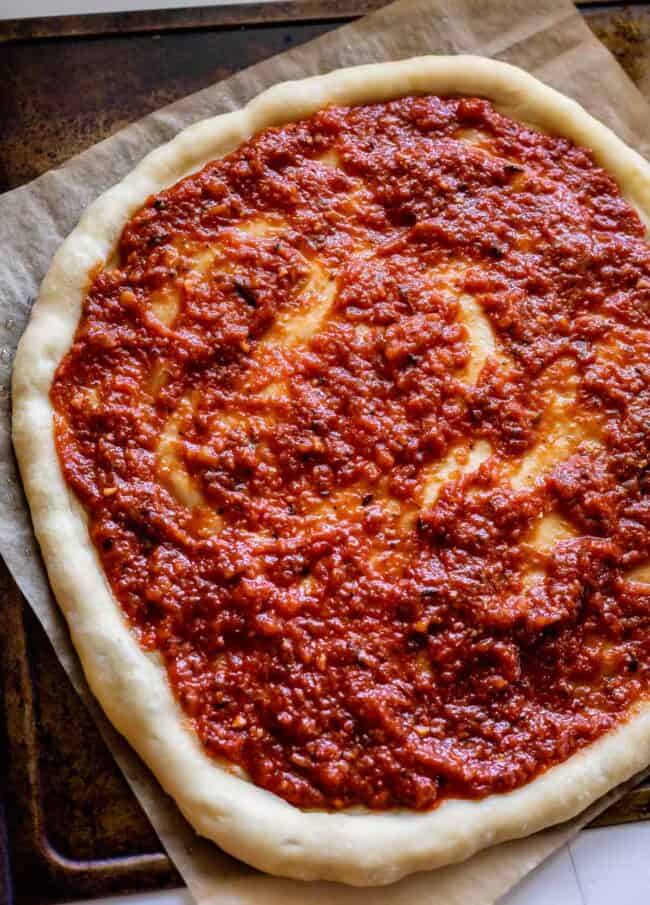 homemade pizza sauce spread on pizza dough