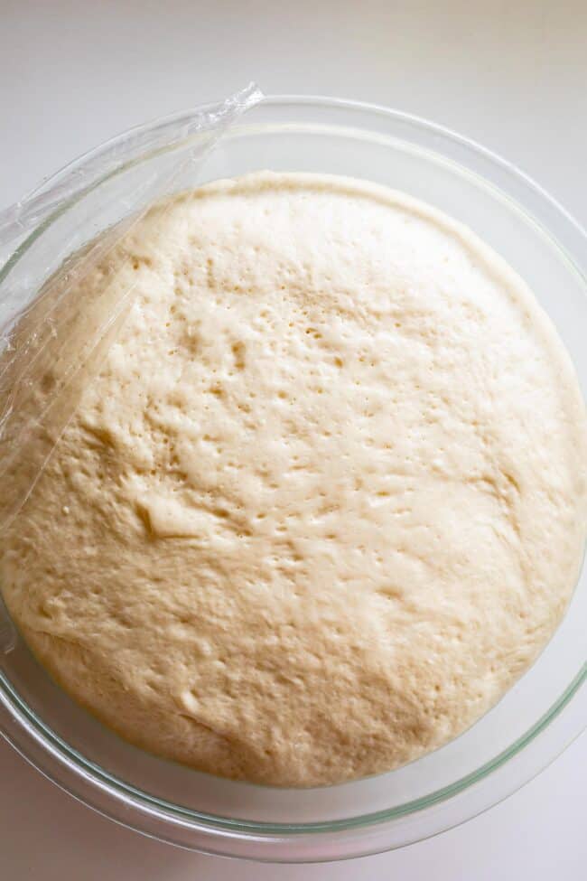 pizza dough in a bowl, risen.