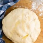 easy pizza dough recipe in a glass bowl with blue napkin