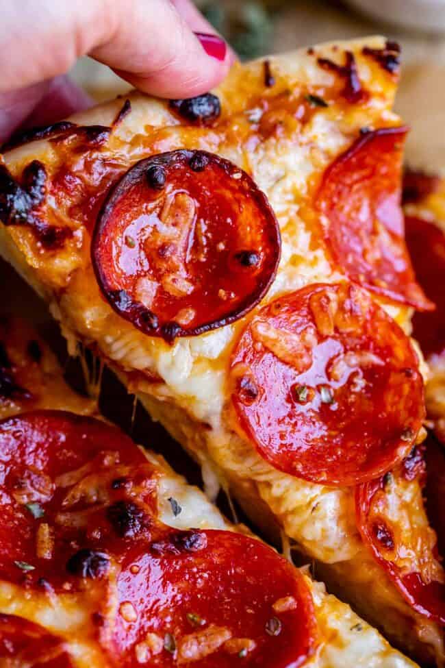 slice of homemade pizza being lifted from pan