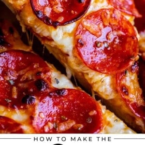 homemade pizza with pepperoni being lifted by hand