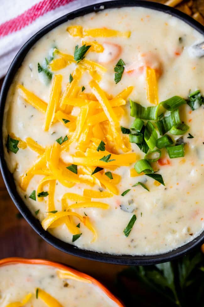 easy potato soup in a black bowl with cheddar and green onions.