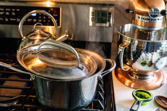 boiling soup on a stove with vented lid.