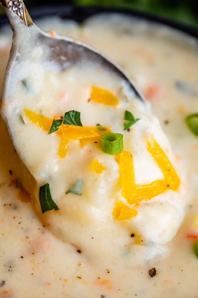 potato soup being lifted with a spoon.