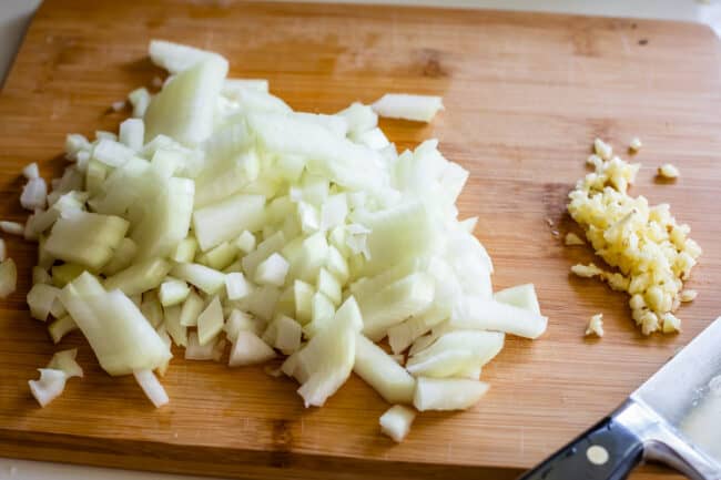 onions and garlic on a cutting board chopped