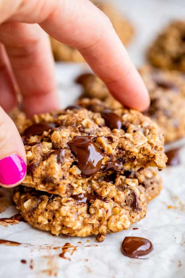 healthy oatmeal chocolate chip cookies being lifted by a hand.
