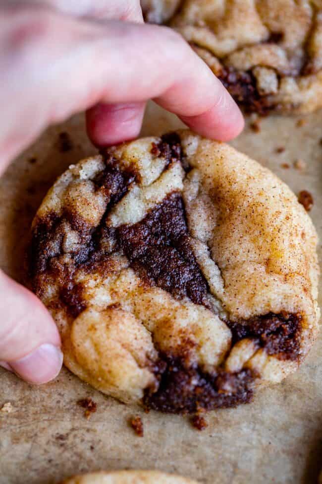 hand picking up cinnamon snickerdoodle cookies