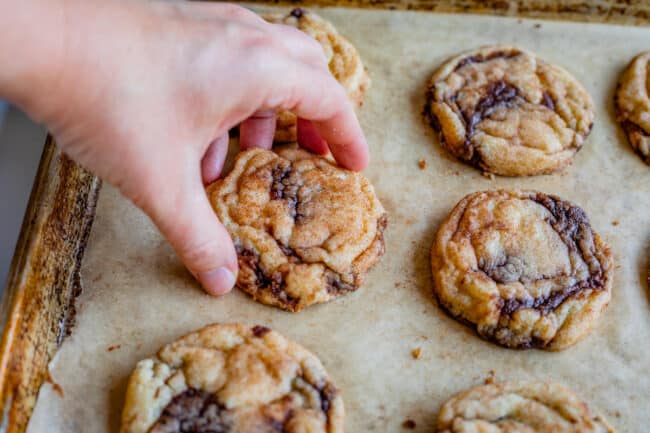 smooshing a cookie in on itself with fingers, to make the cookie chewy