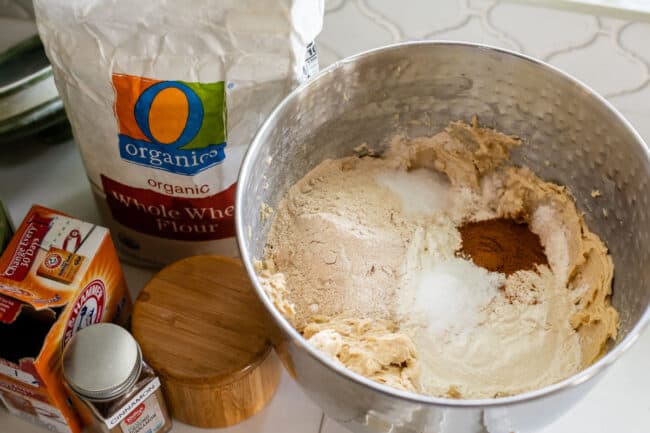 dry ingredients on top of wet ingredients in a stand mixer for cookie dough, plus flour and other ingredients on the side