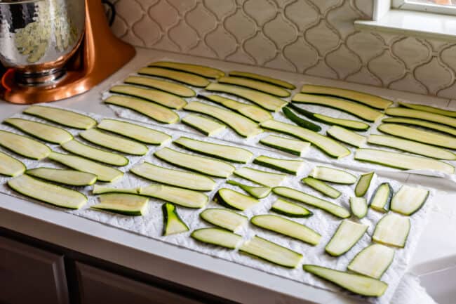 sliced zucchini laid out on paper towels to absorb water