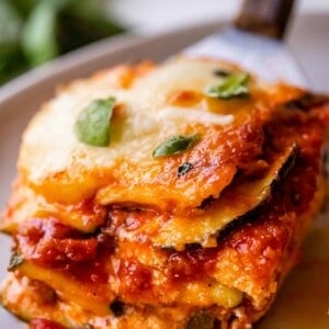 zucchini lasagna recipe being placed on a plate with a spatula