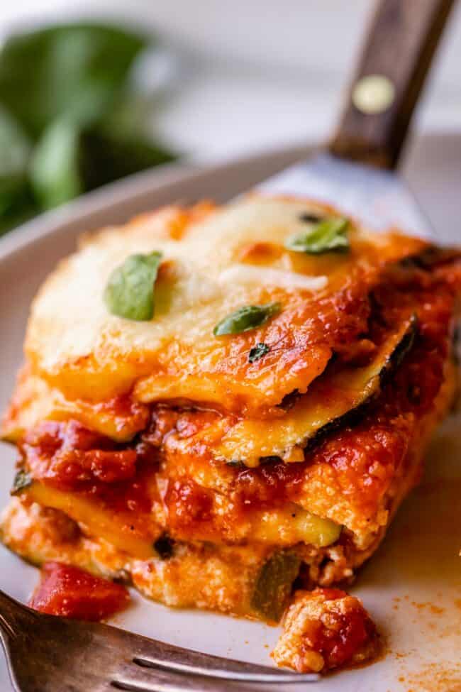 zucchini lasagna recipe being placed on a plate with a spatula