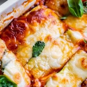 keto zucchini lasagna in a casserole dish topped with basil
