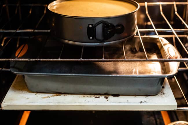 cheesecake in oven with boiling water in pan on a lower rack