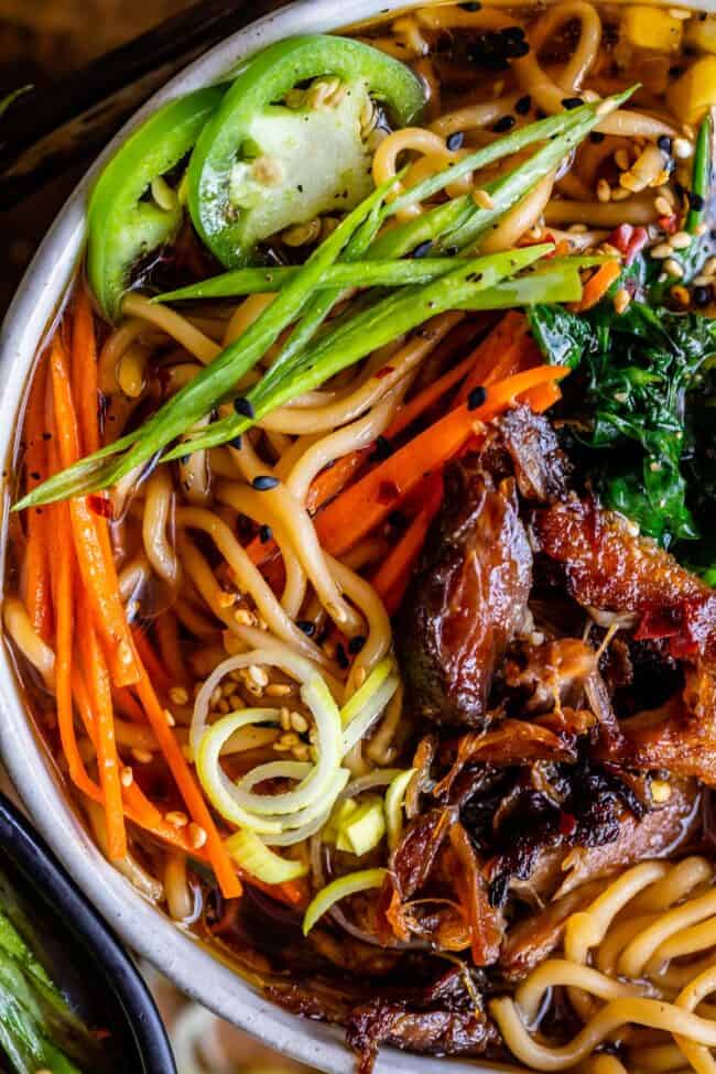 pork ramen noodles with green onions and jalapenos in a bowl