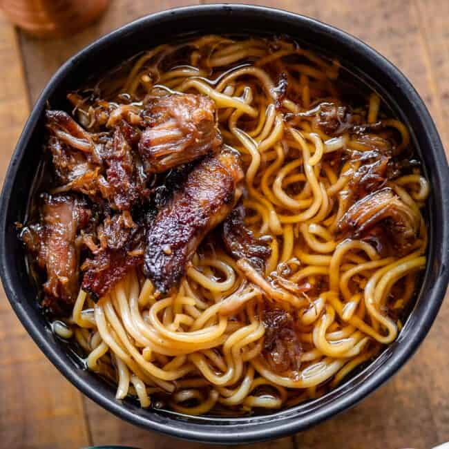 simple black bowl of ramen with crispy pork and no garnishes