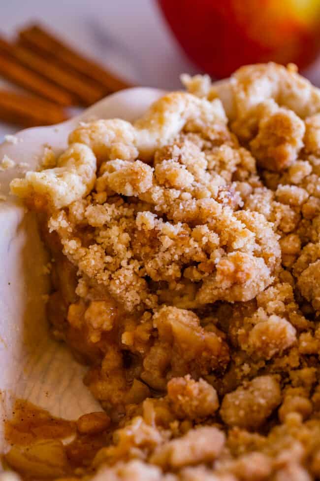 slice of best dutch apple pie still in pan with lots of streusel topping. 