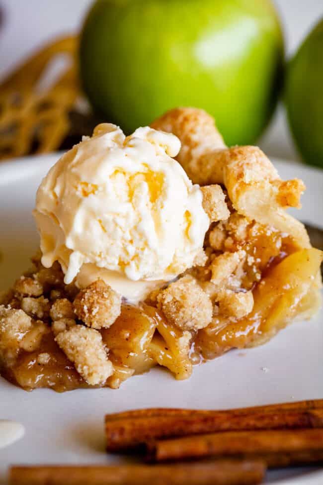 Dutch apple pie slice on a plate with a scoop of vanilla ice cream.