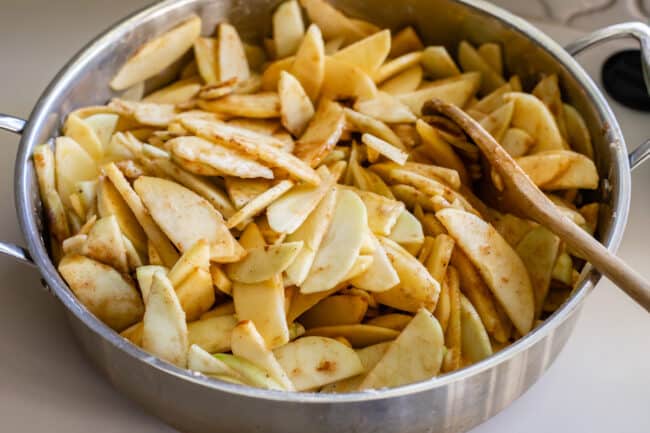 raw sliced apples in a pan with spices and flour